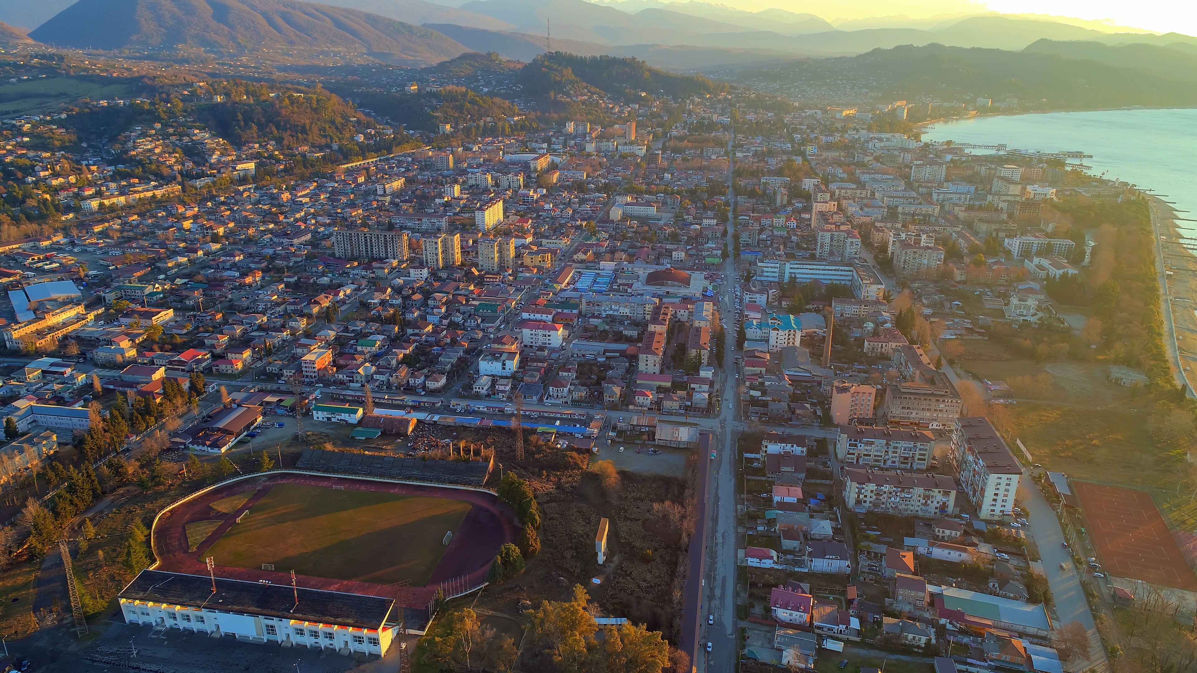 Republican Stadium Sochumi. resort town Sukhum, Abkhazia aerial view from drone. Suburb or outskirts of the city. Private sector or cottage development.
