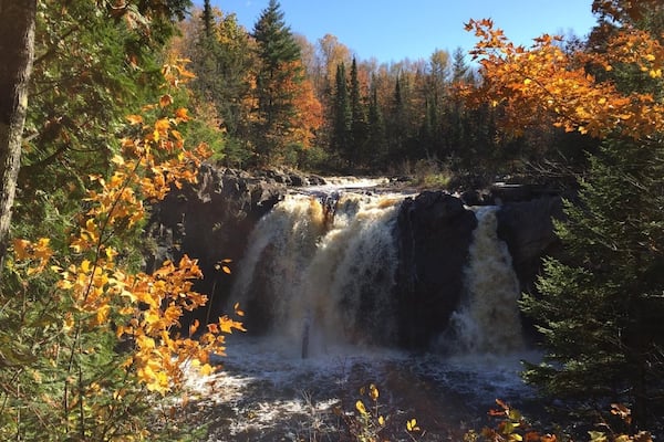 A waterfall surrounded by autumn foliage.