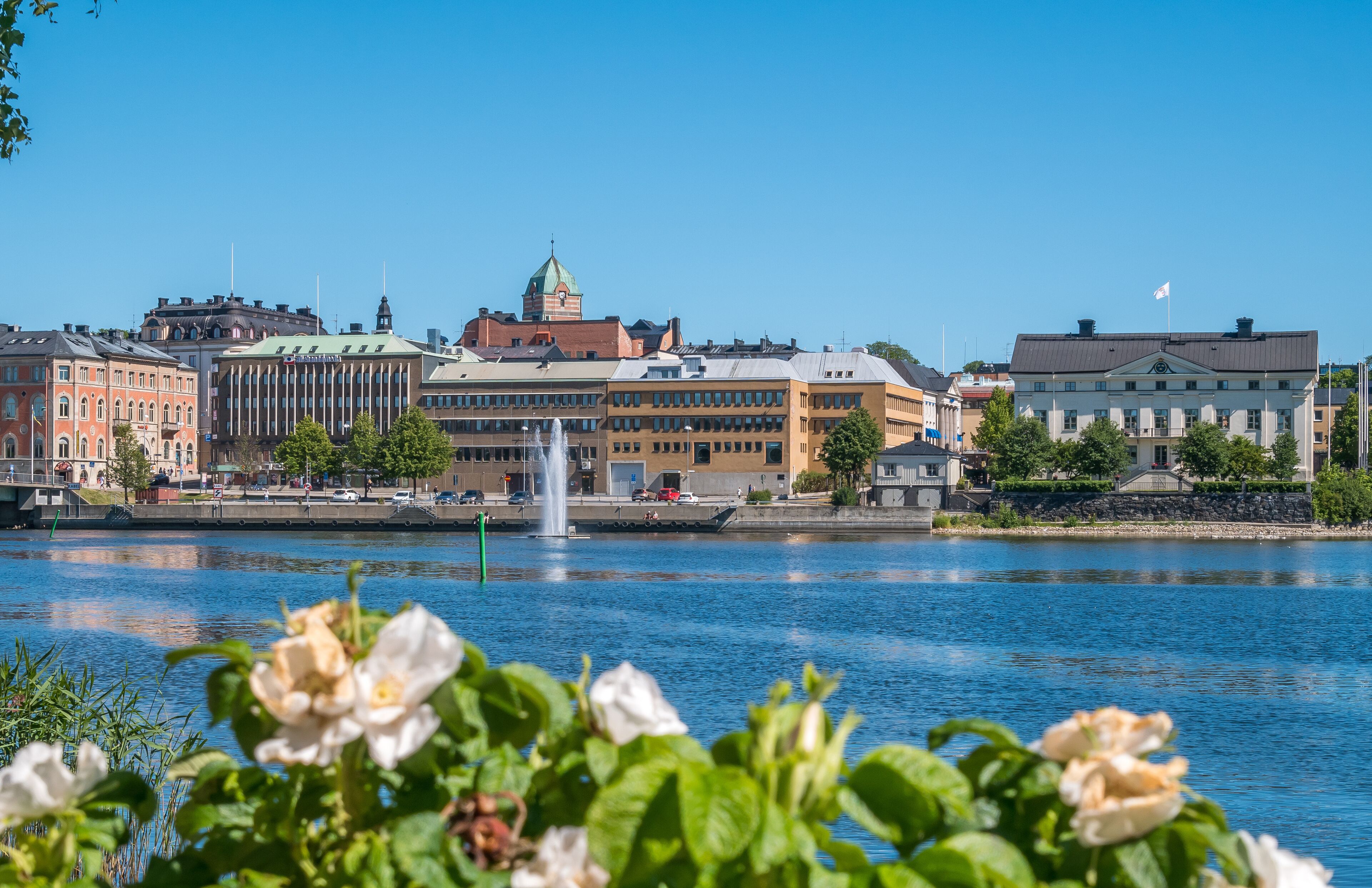 A cityscape with a river, a fountain, and historic buildings.
