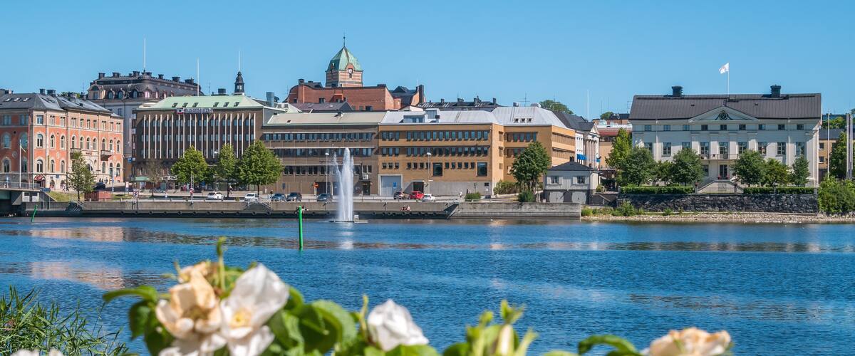 A cityscape with a river, a fountain, and historic buildings.