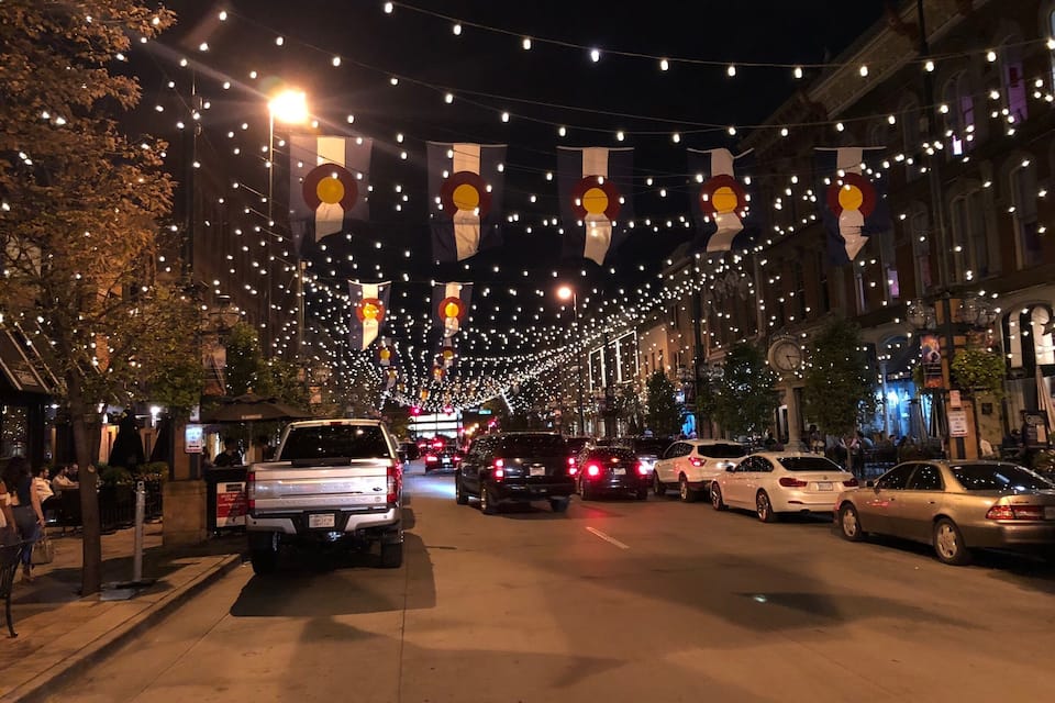 A street at night with string lights and flags.