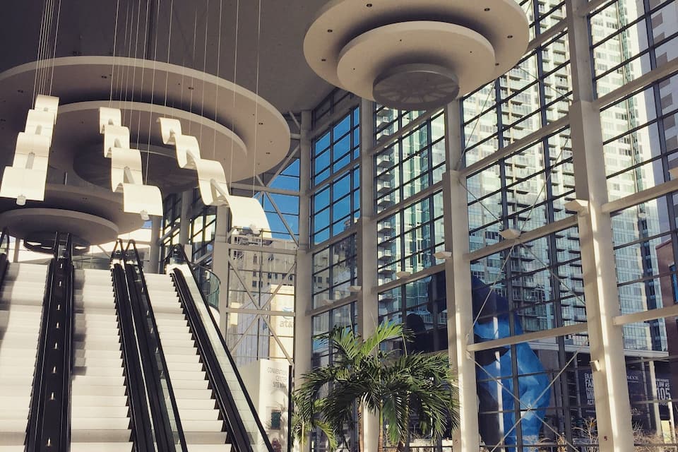 A modern building with large windows and two escalators.