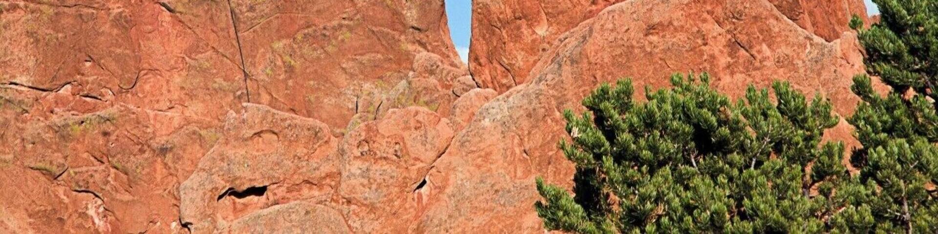 The man on the left has scaled this Mass of rock structure as the birds watch him in the right in the Garden of the Gods, Denver CO, USA.
Situated right next to Colorado Springs off of US Highway 24 lies a small park aptly named Garden of the Gods. The acreage of the park is rather modest, like Red Rocks, but the sandstone formations are quite striking and memorable. Several massive rocks are decorated with jagged profiles with colors ranging from white, mild orange and rich reds. Spires of up to two pitch height are scattered behind these larger rocks. The park is highly developed and has cement trails in places. Climbing is almost exclusively trad, though there are many routes with drilled angles that don't require gear other than draws. Rock quality varies from formation to formation and can be very crumbly. For Front Range denizens who want to get used to soft desert sandstone, this is a great place to experience it. Get used to an audience, as the crowded park has hundreds of visitors on weekends.