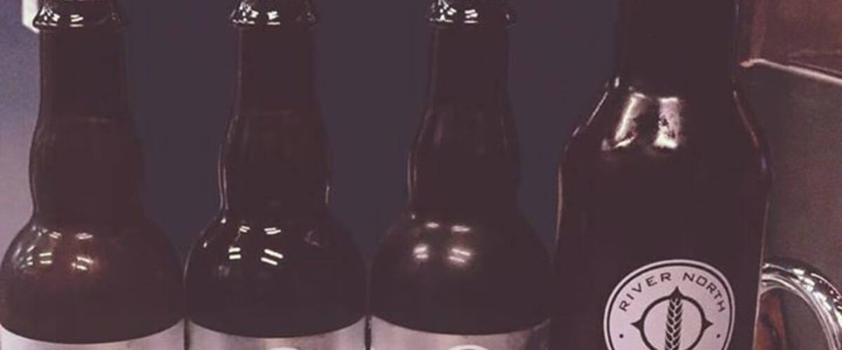 Four bottles of beer with labels, one of which is labeled 'Tripel'.