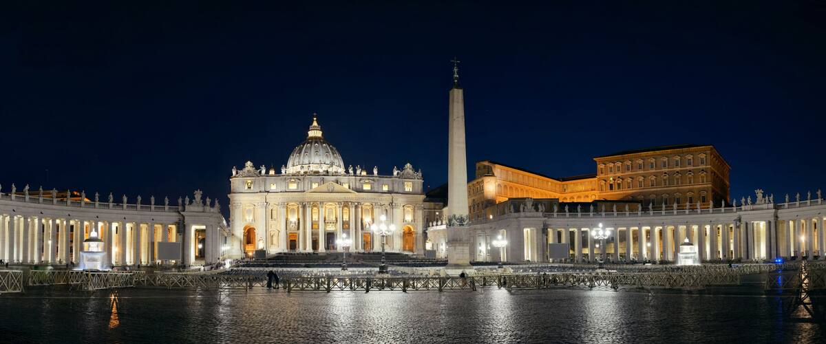 St. Peter's Basilica with its dome and adjacent obelisk, surrounded by a colonnade.