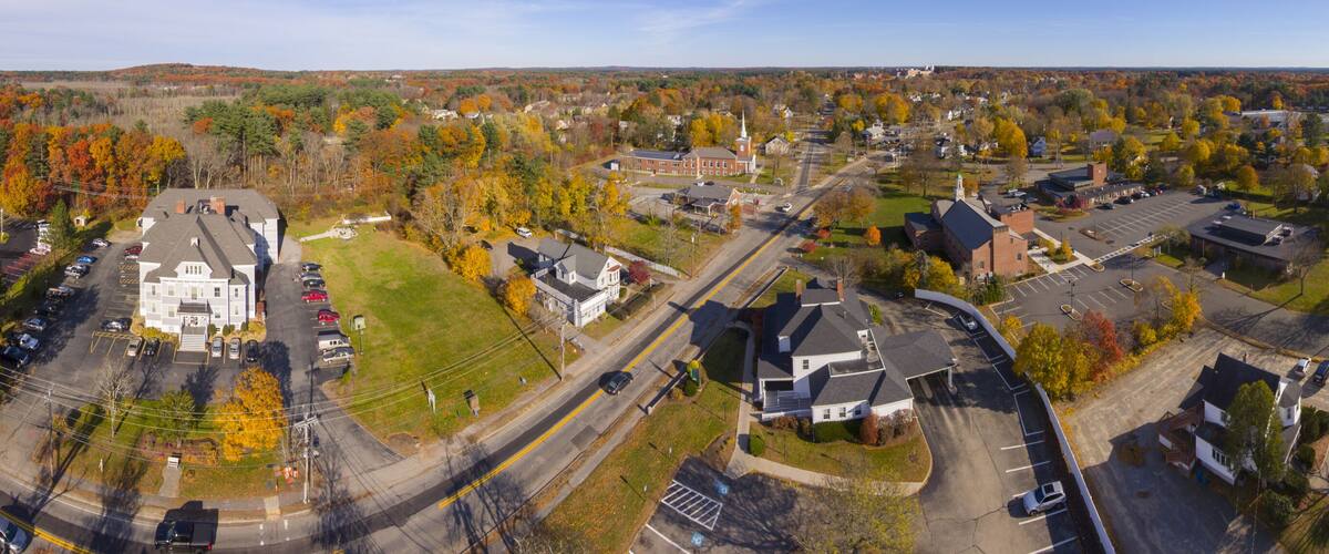 A residential area with a prominent church, residential houses, and a mix of autumn-colored trees.