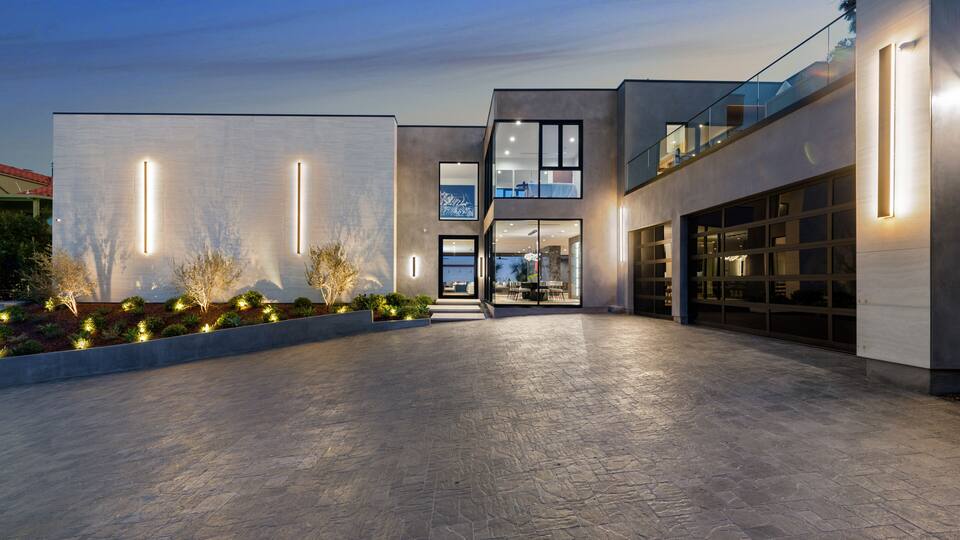 A modern architectural building with a spacious courtyard, large windows, and a well-lit entrance.