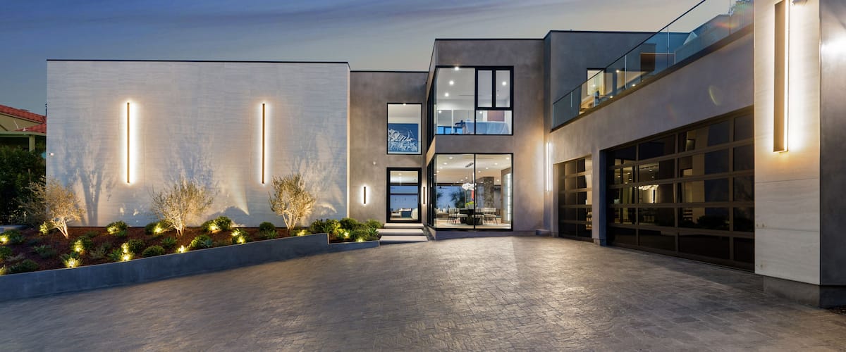 A modern architectural building with a spacious courtyard, large windows, and a well-lit entrance.