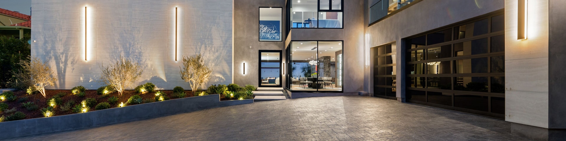 A modern architectural building with a spacious courtyard, large windows, and a well-lit entrance.