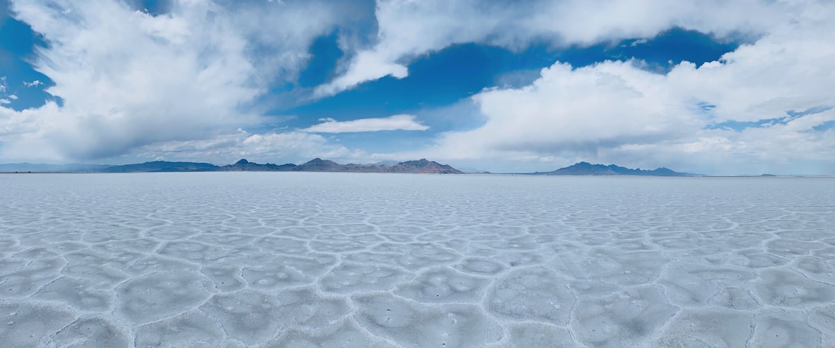 A vast salt flat with a clear sky and distant mountains.