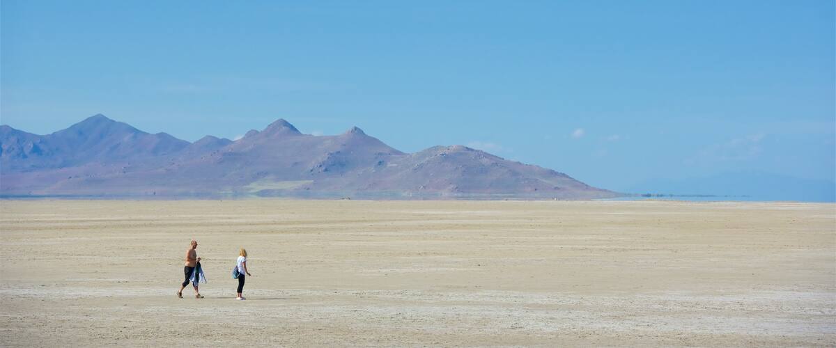 A vast desert landscape with mountains in the background.
