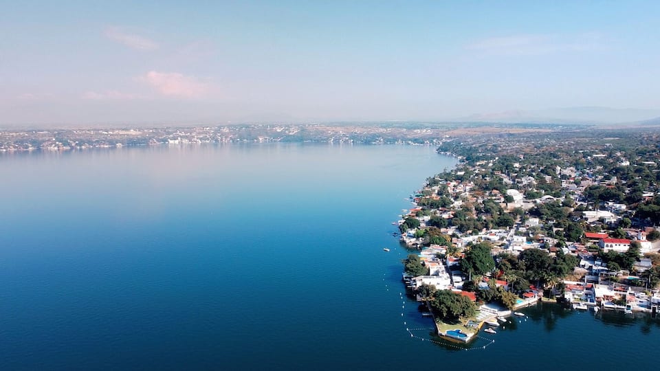 A coastal town with a marina, dense housing, and a large body of water.