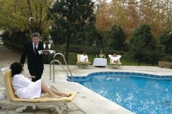 Una piscina al aire libre de temporada, sombrillas, tumbonas
