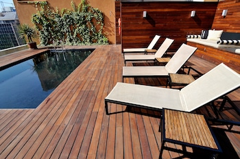 Una piscina al aire libre, tumbonas