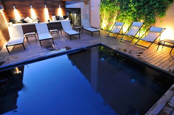 Una piscina al aire libre, tumbonas