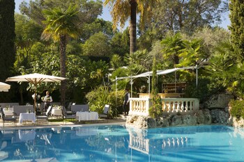 Una piscina al aire libre de temporada, sombrillas, tumbonas
