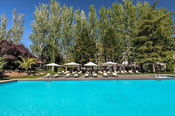 Una piscina al aire libre, sombrillas, tumbonas