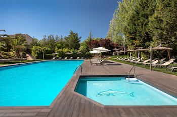 Una piscina al aire libre, sombrillas, tumbonas