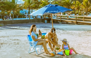 Na praia, guarda-sóis, toalhas de praia