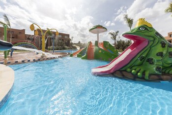 Una piscina al aire libre, sombrillas, tumbonas