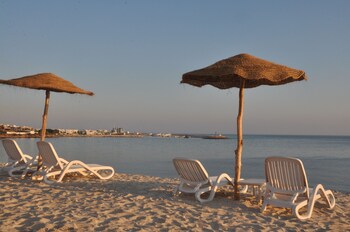 Plage privée, sable blanc, chaises longues, parasols