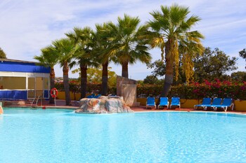 Una piscina cubierta, una piscina al aire libre, sombrillas, tumbonas