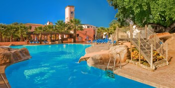 Una piscina cubierta, una piscina al aire libre, sombrillas, tumbonas