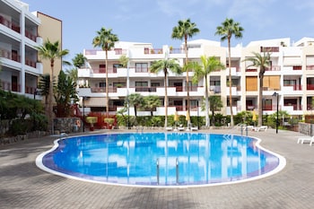 Una piscina al aire libre, sombrillas, tumbonas
