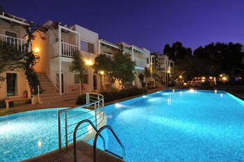 Una piscina al aire libre, sombrillas, tumbonas