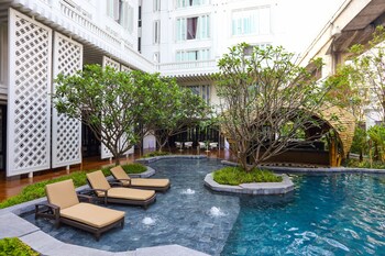 Una piscina al aire libre, tumbonas