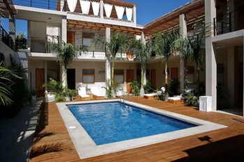 Una piscina al aire libre, sombrillas, tumbonas