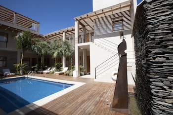 Una piscina al aire libre, sombrillas, tumbonas