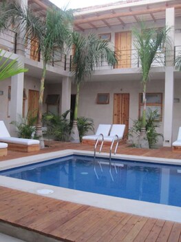 Una piscina al aire libre, sombrillas, tumbonas